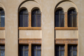 Fototapeta premium Yellow Facade and Arched Windows on a Beige Wall.