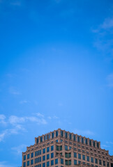 Fototapeta na wymiar Blue Sky with Cirrus Clouds Above a Brown Building Under Construction.