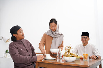 Asian Muslim families have an Iftar dinner. Eating traditional Indonesian food during Ramadan feasting month at home. 