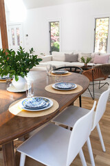 clean modern home with white walls with midcentury table set for dinner