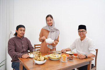 Asian Muslim families have an Iftar dinner. Eating traditional Indonesian food during Ramadan feasting month at home. 