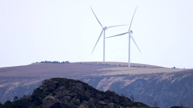 The wind turbines on Haramsfjellet, just north of &Aring;lesund city, filmed from the mainland, Skjeltene, a day with lots of wind and good rotation on the turbines.