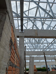 Obraz premium structure steel roof building construction. scene gabal roof structure with steel metal under construction building view and blue sky. structure for house, roof gable, construction home, real estate.