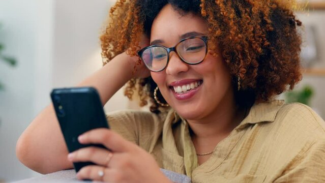 Laugh, phone and black woman on a sofa for social media, texting or funny meme in her home. Online, comic and girl relax with smartphone on couch, chatting and reading post or update in living room