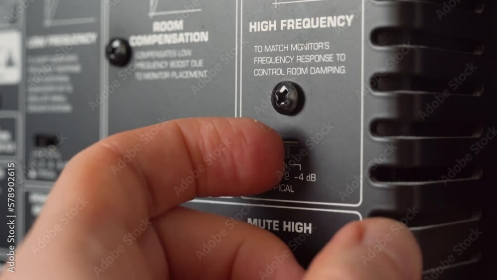 Poster man adjusting a speaker setting of a studio monitor. close up