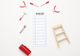Flatlay picture of to do list note with tools, tool box and ladder. Repairing to do list concept.