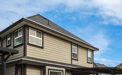 Top of a house with nice windows in the blue sky background. Beautiful Home Exterior. Real Estate Exterior