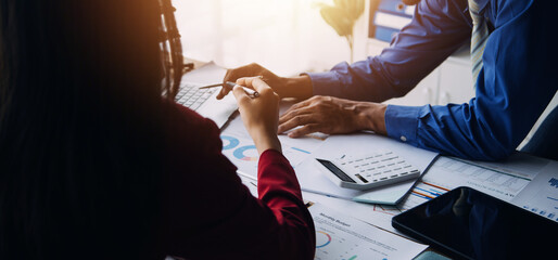 Group of confident business people point to graphs and charts to analyze market data, balance sheet, account, net profit to plan new sales strategies to increase production capacity.