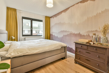 a bedroom that has been painted on the wall, and is next to a bed with white sheets in it