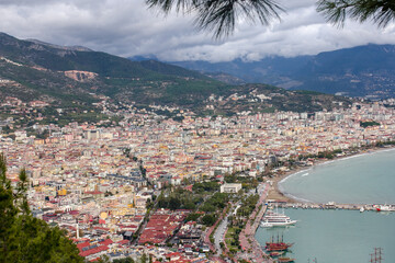  Top view of the bay area with firs, old city, yachts, boats and mountains in Alanya, Turkey