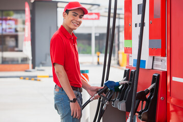 Man holding pump nozzle for service at gas station. male employee worker fueling oil car. business...