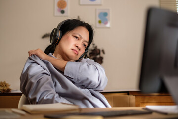 asian woman shoulder ache office syndrome when working long time at home