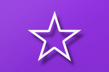 paper cut star shape with light and shadow Placed on a purple paper background.