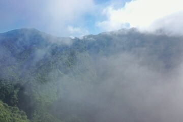 Panoramic view of a rainforest valley on Flores surrounded by a dense layer of haze clouds.