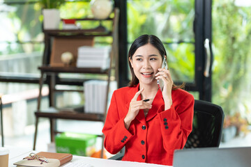 Happy business woman talking on mobile phone while analyzing weekly schedule in her notebook