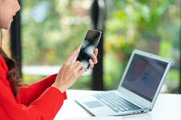 Happy business woman talking on mobile phone while analyzing weekly schedule in her notebook