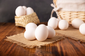 Many white chicken eggs on rustic wooden table. Very popular nutritious and economic food product.