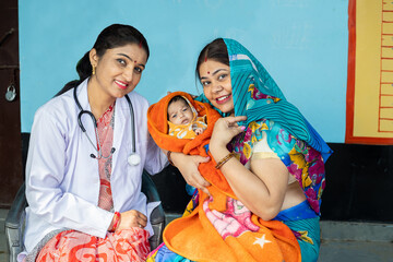 Young indian pediatrician doctor sitting with Mother and her new born baby, Rural india healthcare,...