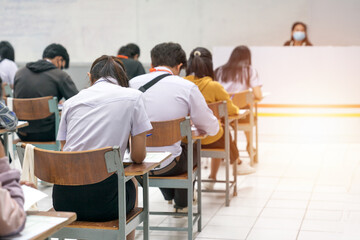 University students concentrating on doing examinations in the classroom