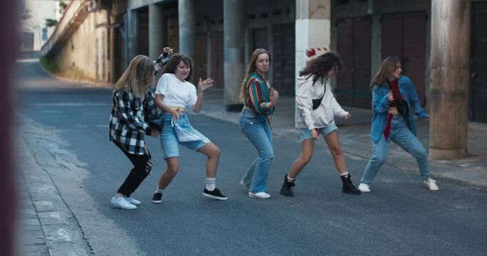 Youth concept performers schoolgirls dancing freestyle hiphop actions movements rehearsal time outside on street girls having fun spending time funny preforming time .