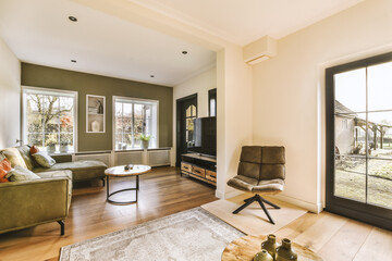 a living room with couches, coffee table, television and large sliding glass door that opens onto...