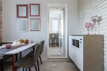 Stylish dining room interior design with dining table. Creative walls, white and wooden pannels.