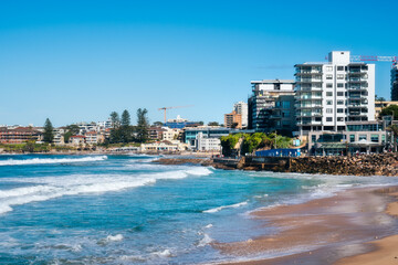 Coastal erosion at North Cronulla Beach in Sydney, NSW, Australia. A huge amount of sand was ripped from the beach and the ocean reached close up to the sea wall and nearby buildings in June 2022. - obrazy, fototapety, plakaty