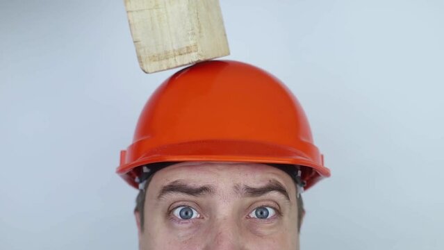 Safety helmet. Brick and a board fall on builder head. Saving a life due to wearing a protective construction helmet. Protection of worker from accidents. Falling objects from a height. Slow mo effect