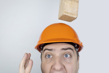 Safety helmet. Brick and a board fall on builder head. Saving a life due to wearing a protective...