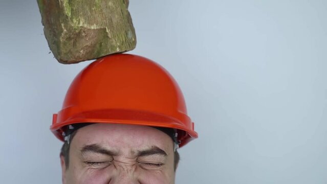 Safety helmet. Brick and a board fall on builder head. Saving a life due to wearing a protective construction helmet. Protection of worker from accidents. Falling objects from a height. Slow mo effect