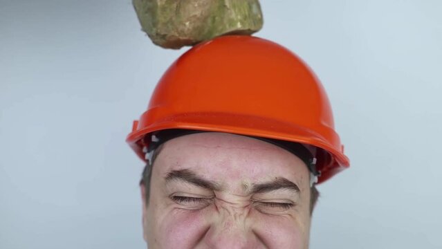 Safety helmet. Brick and a board fall on builder head. Saving a life due to wearing a protective construction helmet. Protection of worker from accidents. Falling objects from a height. Slow mo effect