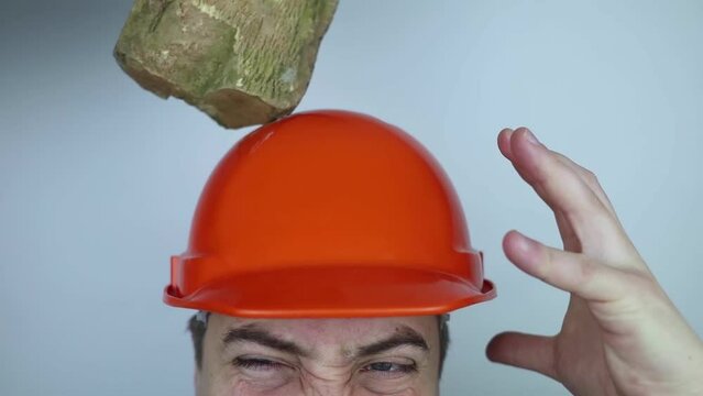 Safety helmet. Brick and a board fall on builder head. Saving a life due to wearing a protective construction helmet. Protection of worker from accidents. Falling objects from a height. Slow mo effect