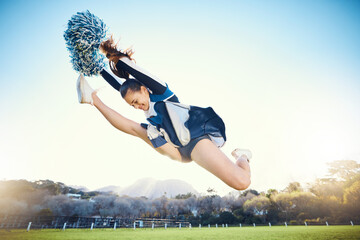Sports, performance and woman cheerleader jumping while performing a routine on the field at an...