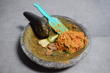 Photo making traditional spices using a mortar and pestle.