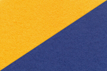 Fototapeta na wymiar Texture of craft yellow and navy blue paper background, half two colors, macro. Vintage dense kraft golden cardboard.