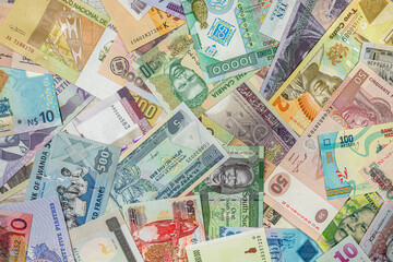 close-up of African currency of various colors shapes  denominations filled the entire table.