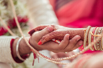 Groom and bride holding hands at a hindu wedding ceremony