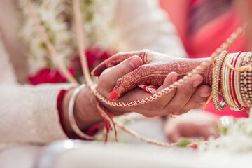 Groom and bride holding hands at a hindu wedding ceremony