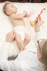 Obraz na płótnie Canvas Female masseur doing baby massage for foot little infant baby child
