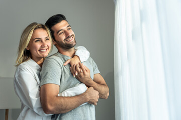 Caucasian young couple spend free leisure time together in living room. 