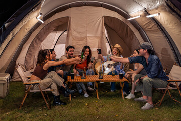 Group of diverse friend having outdoors camping party together in tent.  - obrazy, fototapety, plakaty
