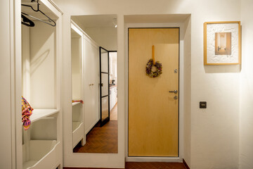 Stylish interior of apartment hallway in white tones with wooden doors