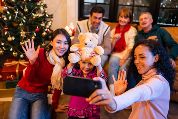 Multi-ethnic big family use mobile phone video call online to relative. 