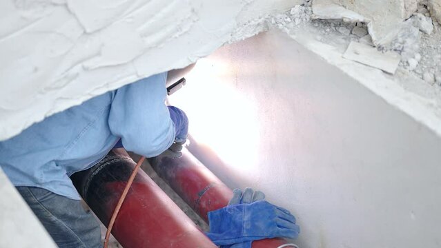 Welder working welding pipeline underground installation in construction site wearing safety mask equipment for protective accident from work.ect