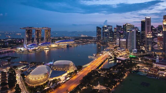 Time lapse of Aerial Cloudy sky at Marina Bay Singapore city skyline from day to night