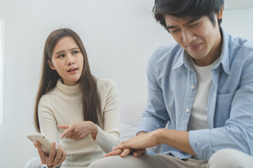 Infidelity, suspicion asian young couple love fight relationship, wife holding cellphone,...