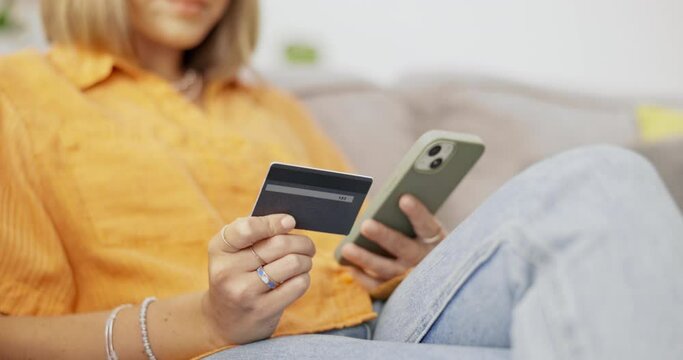 Phone, credit card and woman on a sofa doing online shopping on website retail store. Technology, ecommerce and hands of female paying bills with internet banking on cellphone in living room at home.