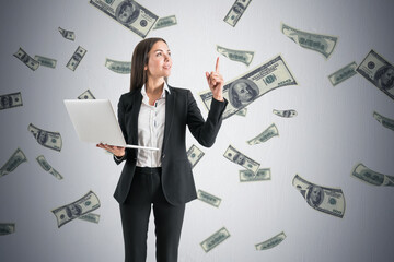 Business success and bonus concept with satisfied woman with modern laptop on light wall background...