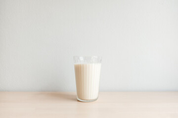 Soy milk in glass on wooden table background, healthy concept.