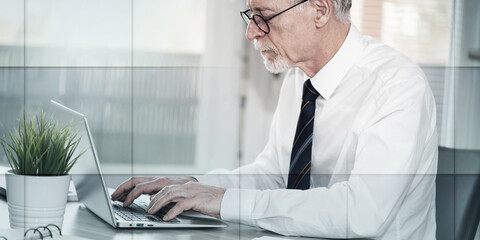 Senior businessman working on laptop, geometric pattern